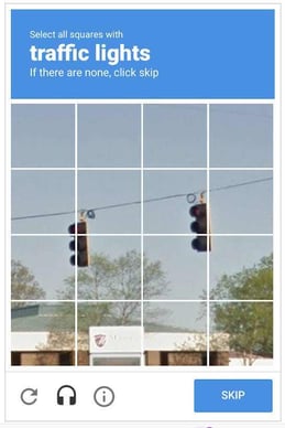 An image of a CAPTCHA test asking the user to select all squares with traffic lights.